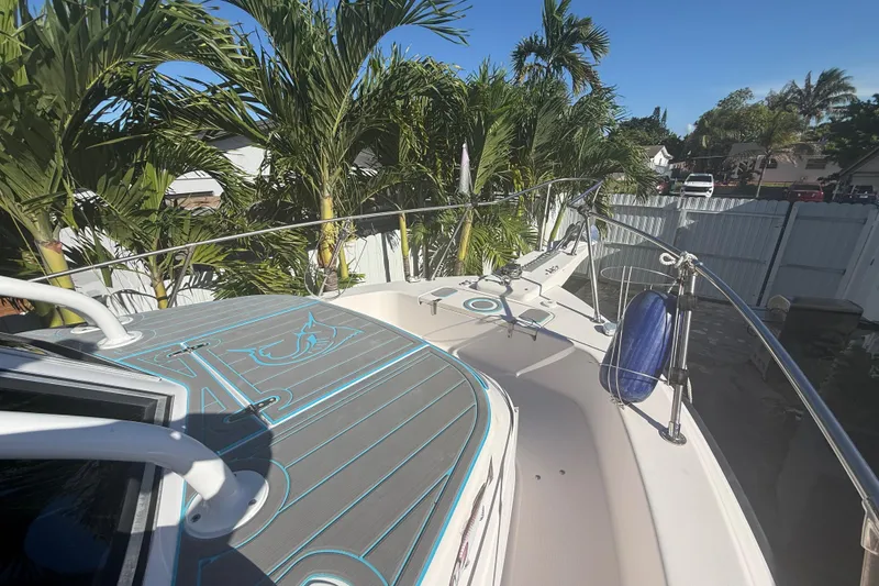 Slide: The Image of 1996 Grady-White Sailfish 272 boat docked, surrounded by lush palm trees. - 93