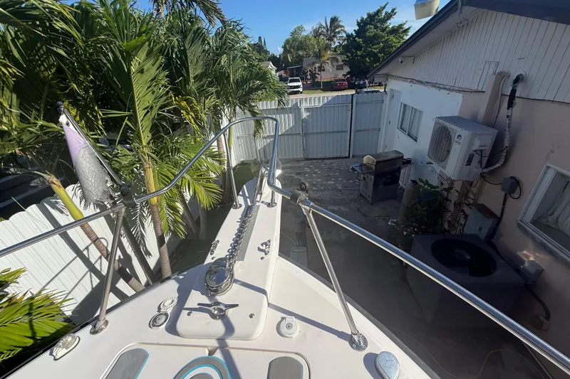 Slide: The Image of Bow view of 1996 Grady-White Sailfish 272, docked near tropical foliage and residential area. - 95