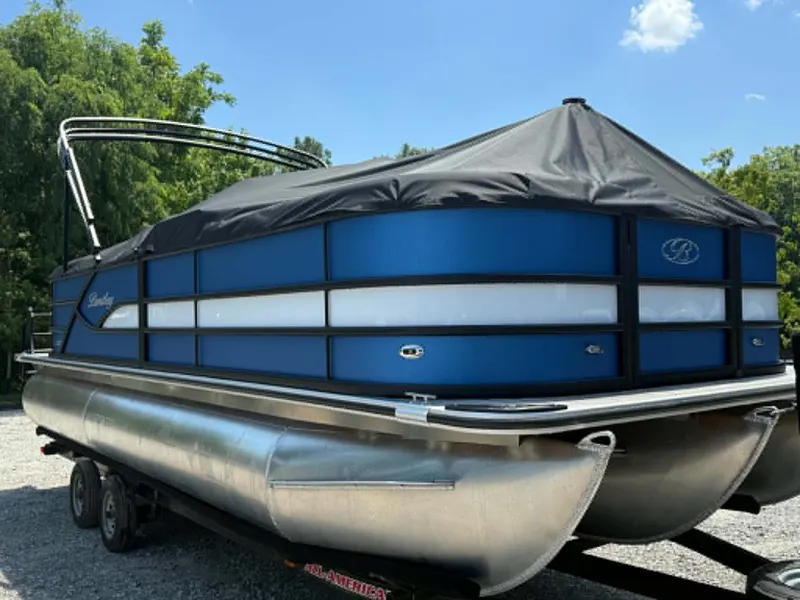 Slide: The Image of 2026 Bentley Pontoons Legacy 223 Navigator on trailer, blue hull, black cover. - 16