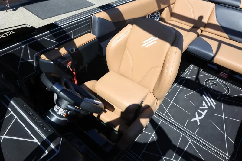 Slide: The Image of 2021 ATX Surf Boats 22 Type-S interior with tan seating and modern steering wheel design. - 19