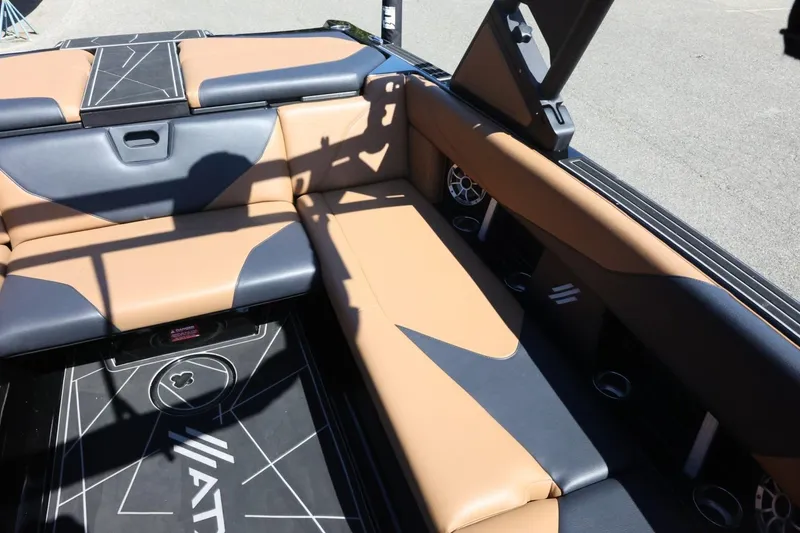 Slide: The Image of 2021 ATX Surf Boats 22 Type-S interior with tan and black seating, featuring cup holders and speakers. - 23