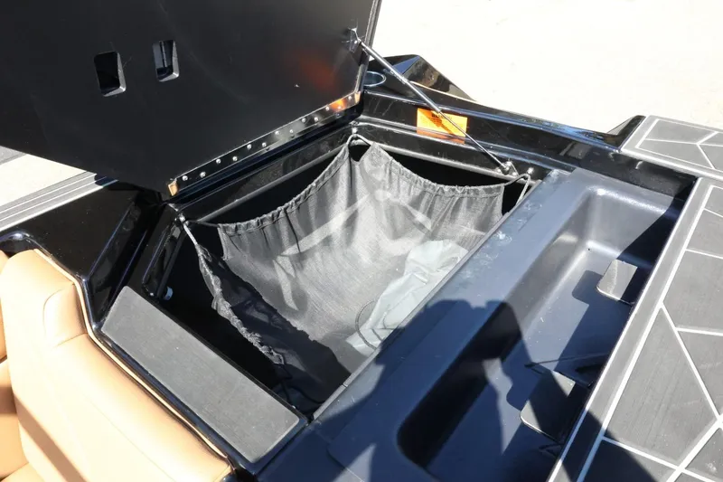 Slide: The Image of Storage compartment of 2021 ATX Surf Boats 22 Type-S with black netting and tan seating. - 45