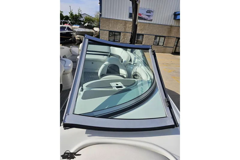 Slide: The Image of 2019 Crownline 275 SS boat interior with windshield and seating, displayed outdoors. - 101
