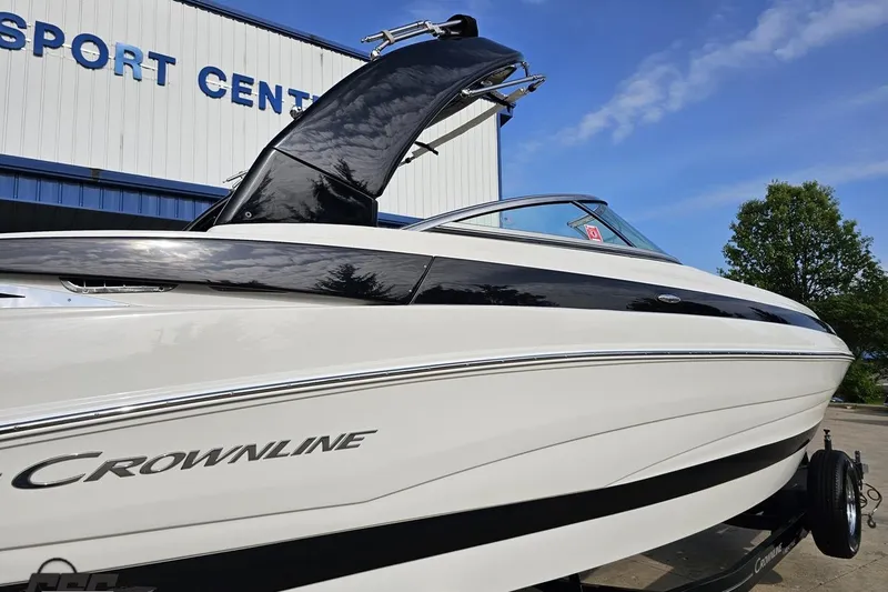 Slide: The Image of 2019 Crownline 275 SS boat displayed outside a sports center under a clear blue sky. - 11