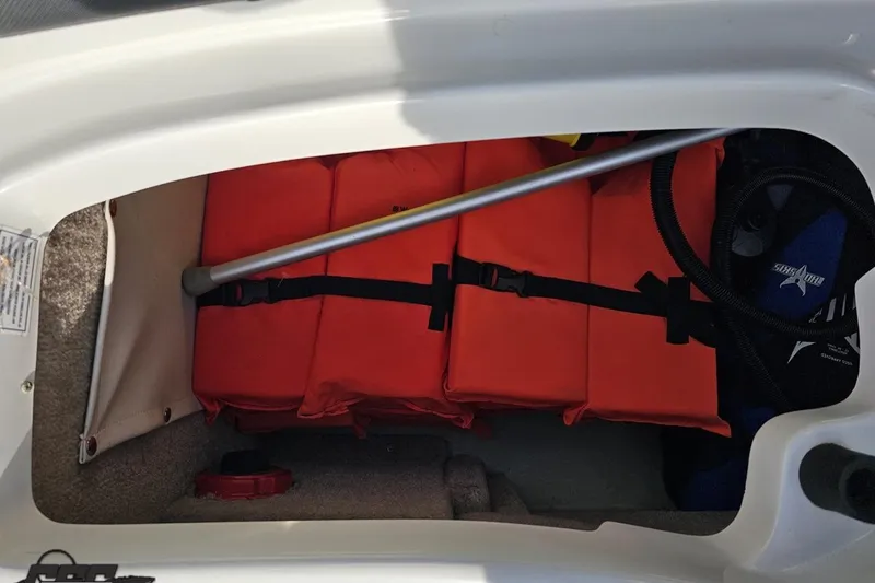 Slide: The Image of Storage compartment in a 2019 Crownline 275 SS boat with orange life jackets. - 112