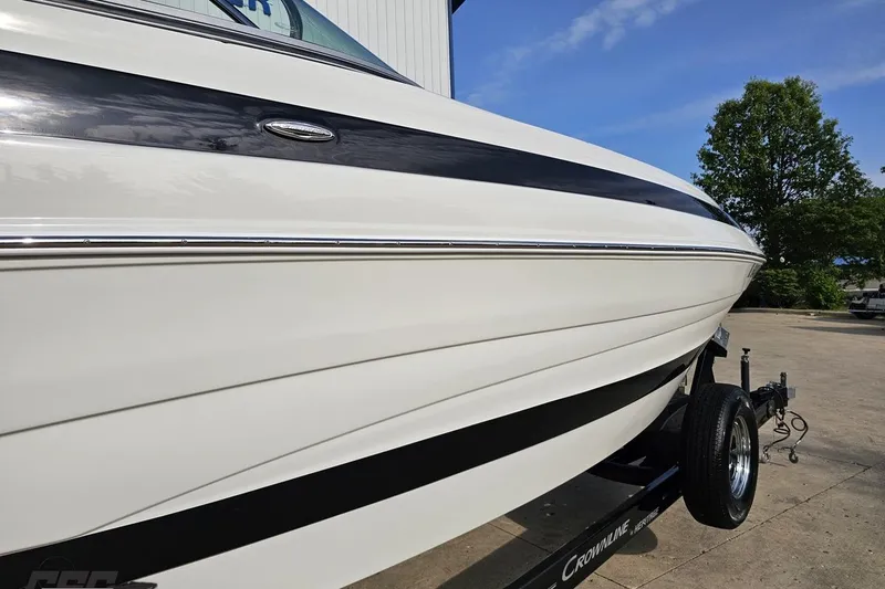 Slide: The Image of 2019 Crownline 275 SS boat on trailer, sleek white and black design. - 13