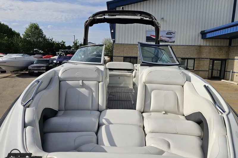 Slide: The Image of 2019 Crownline 275 SS boat with white leather seating, docked near a building. - 21