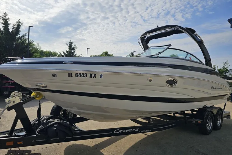 Slide: The Image of 2019 Crownline 275 SS boat on trailer under a partly cloudy sky. - 24