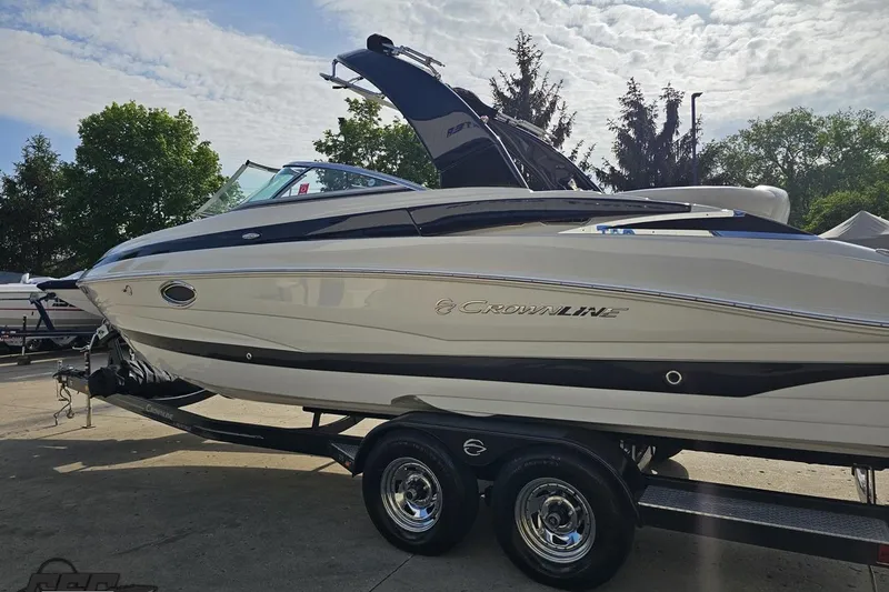 Slide: The Image of 2019 Crownline 275 SS boat on trailer under a partly cloudy sky. - 31