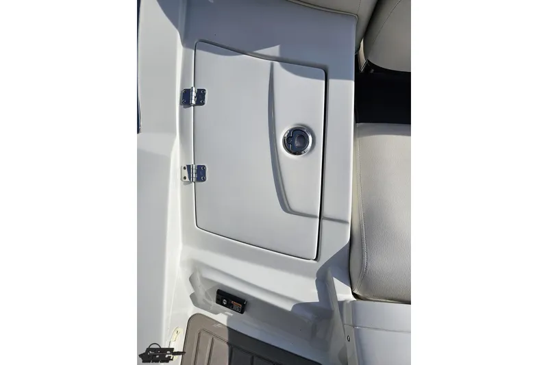 Slide: The Image of 2019 Crownline 275 SS boat storage compartment with sleek design and chrome handle. - 46