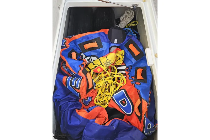 Slide: The Image of Storage compartment of 2019 Crownline 275 SS boat with colorful inflatable and ropes. - 64