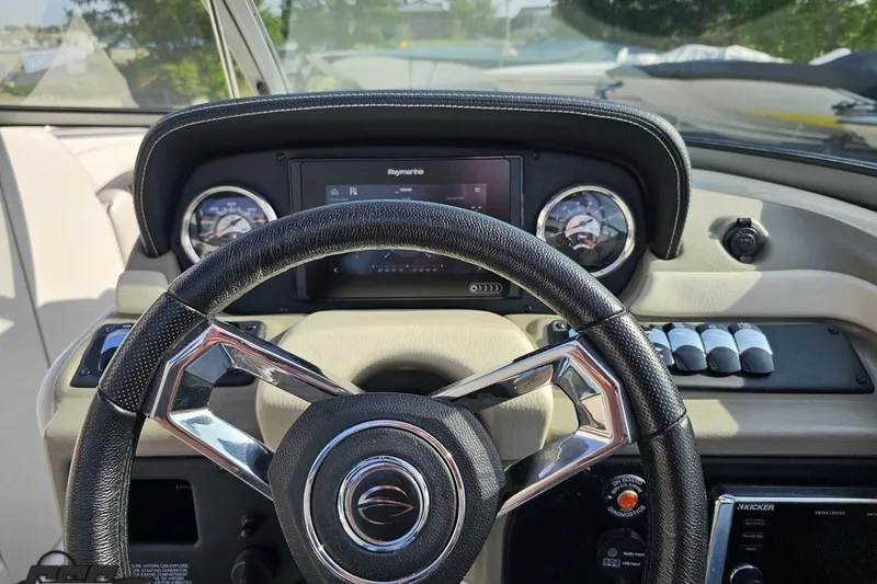 Slide: The Image of Steering wheel and dashboard of 2019 Crownline 275 SS boat, featuring modern controls and gauges. - 83