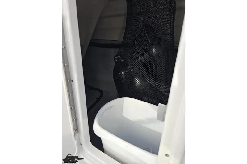 Slide: The Image of Storage compartment in 2019 Crownline 275 SS boat with netting and container. - 88