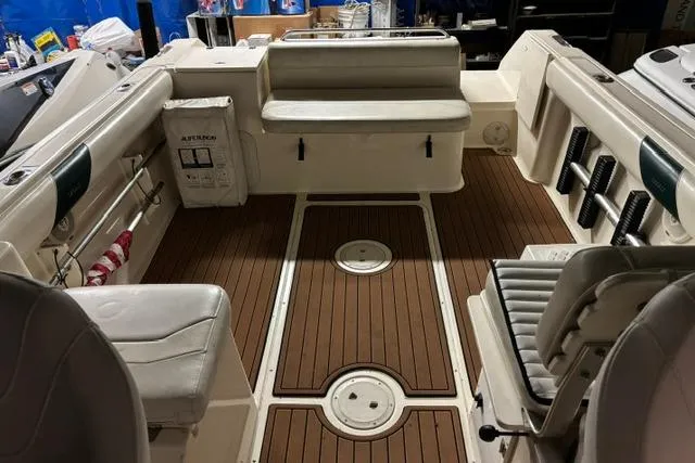 Slide: The Image of 1999 Pursuit 2460 Denali boat interior with seating and wooden flooring. - 12