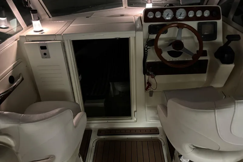 Slide: The Image of 1999 Pursuit 2460 Denali boat interior with steering wheel and seating area. - 13