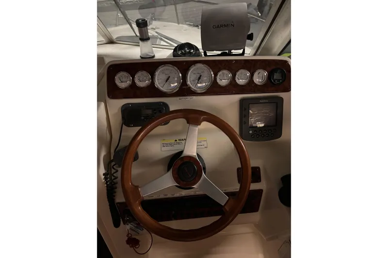 Slide: The Image of 1999 Pursuit 2460 Denali boat dashboard with steering wheel and Garmin navigation system. - 15