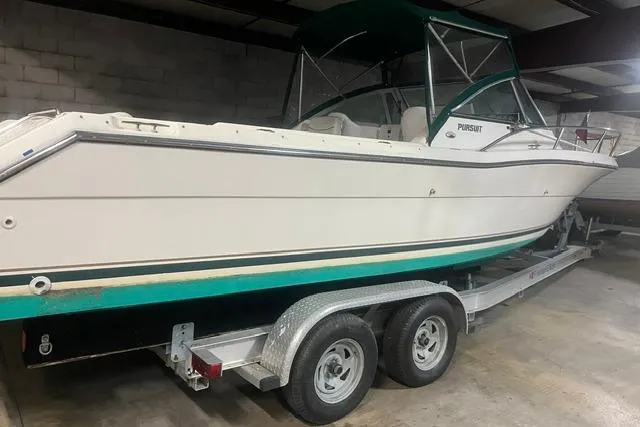 Slide: The Image of 1999 Pursuit 2460 Denali boat on trailer in indoor storage. - 20