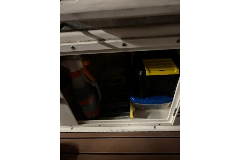 Slide: The Image of Storage compartment on a 1999 Pursuit 2460 Denali boat with cleaning supplies. - 4