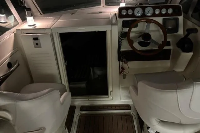 Slide: The Image of 1999 Pursuit 2460 Denali boat interior with steering wheel and seating. - 5