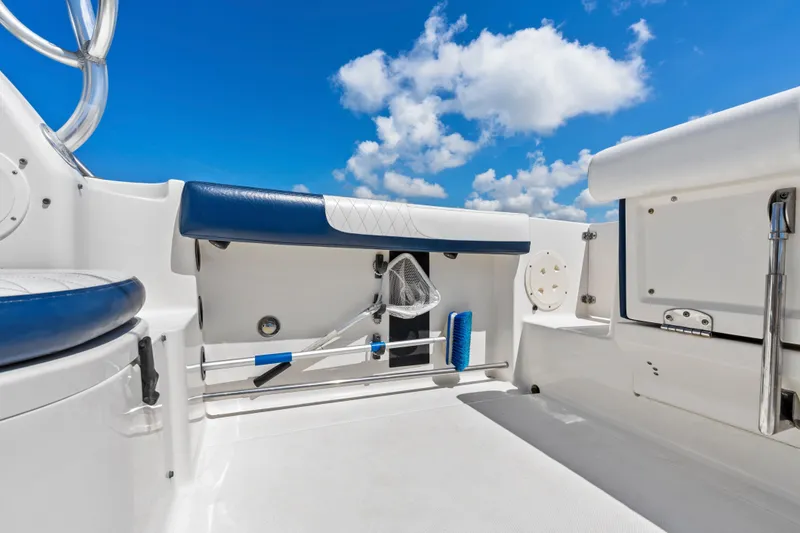 Slide: The Image of 2009 Robalo R245 Walkaround boat interior with blue and white seating under a clear sky. - 10