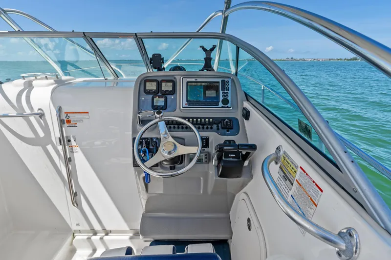Slide: The Image of 2009 Robalo R245 Walkaround boat cockpit with steering wheel and navigation equipment. - 11