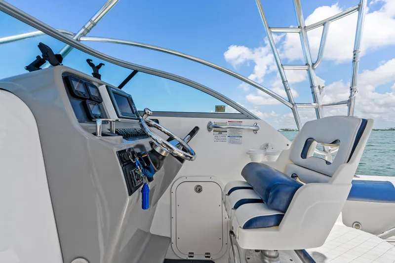 Slide: The Image of 2009 Robalo R245 Walkaround boat cockpit with steering wheel and navigation controls. - 12