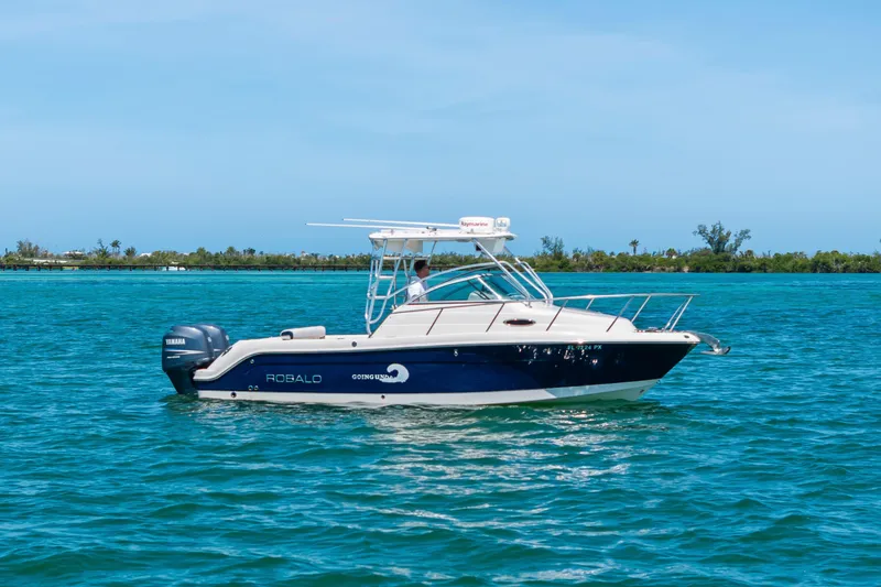 Slide: The Image of 2009 Robalo R245 Walkaround boat cruising on clear blue water. - 2