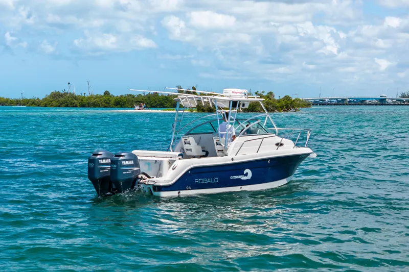 Slide: The Image of 2009 Robalo R245 Walkaround boat with twin Yamaha engines on blue water. - 3