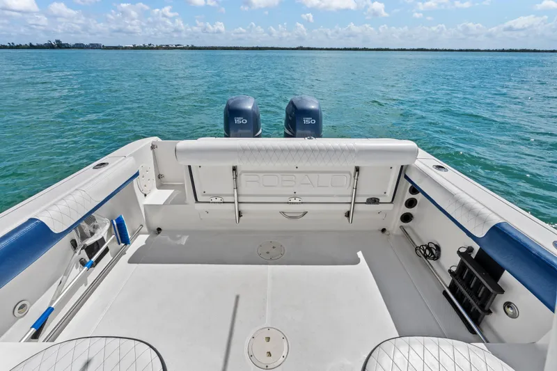 Slide: The Image of 2009 Robalo R245 Walkaround boat deck with twin engines on a sunny day. - 8