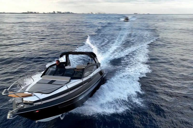 Slide: The Image of 2027 Hanover 305 boat cruising on open water, creating a dynamic wake. - 10