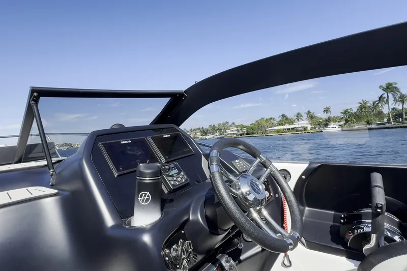 Slide: The Image of Helm of Hanover 305 boat, 2027 model, with steering wheel and navigation screens on a sunny day. - 15