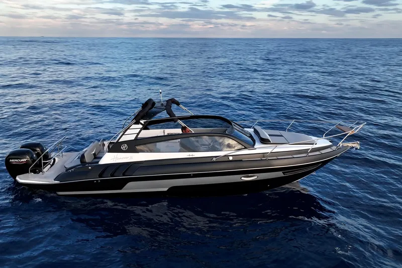 Slide: The Image of 2027 Hanover 305 boat cruising on open sea under a partly cloudy sky. - 2