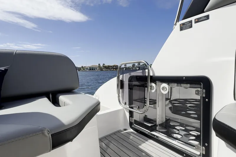 Slide: The Image of Luxury seating and glass door on 2027 Hanover 305 boat, with scenic waterfront view. - 20