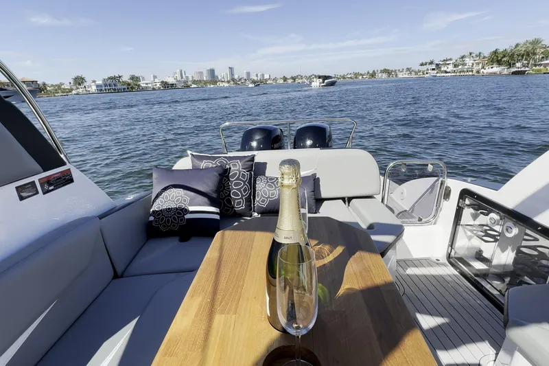 Slide: The Image of Luxurious Hanover 305 yacht interior with champagne, cushions, and scenic waterfront view, 2027 model. - 23