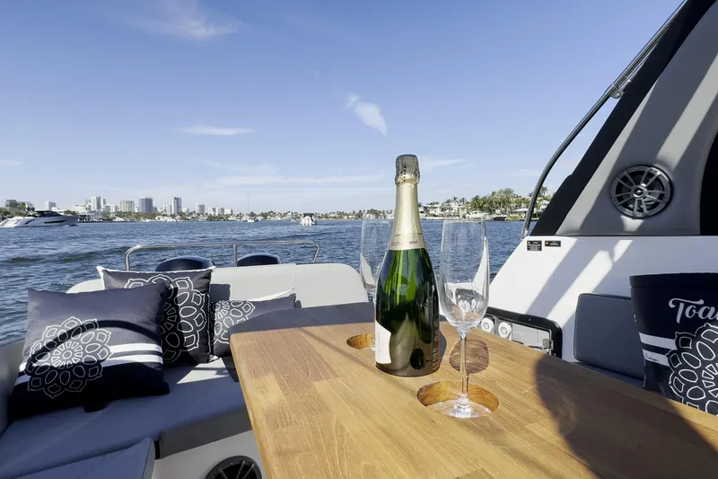 Slide: The Image of Luxurious Hanover 305 boat interior with champagne and glasses, city skyline in the background, 2027 model. - 24