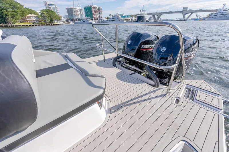 Slide: The Image of Luxury Hanover 305 boat deck with twin Mercury engines, docked near waterfront buildings, 2027 model. - 26