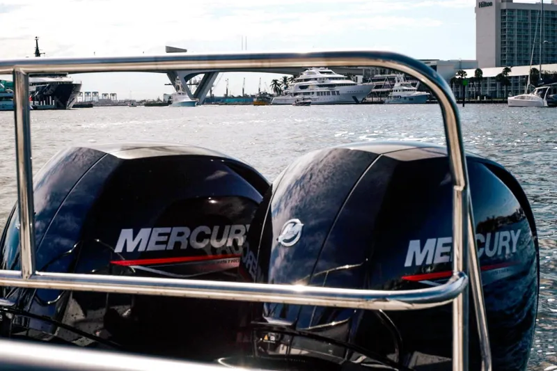 Slide: The Image of Twin Mercury outboard motors on a Hanover 305 boat, 2027, docked near luxury yachts. - 34