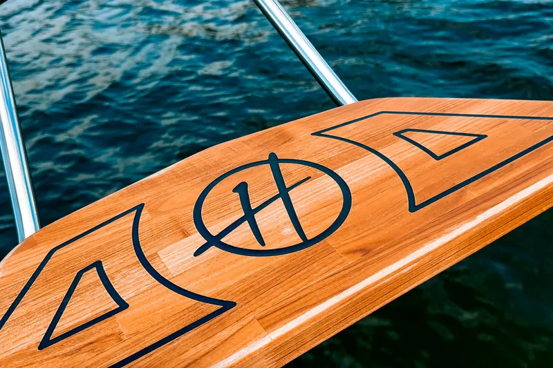 Slide: The Image of Wooden deck of Hanover 305 boat, 2027 model, with water in the background. - 35