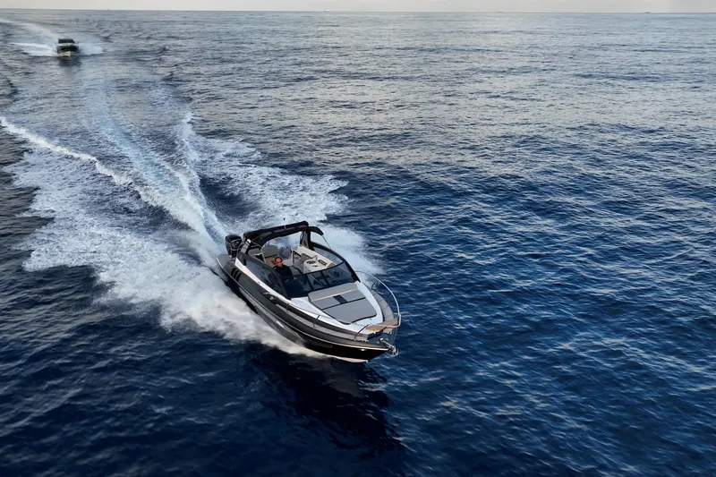 Slide: The Image of A 2027 Hanover 305 boat cruising swiftly on open water. - 6