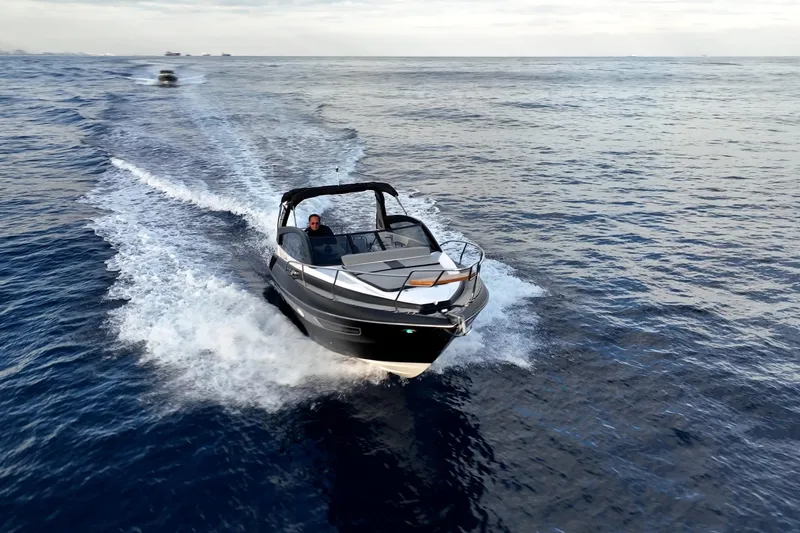 Slide: The Image of A sleek 2027 Hanover 305 boat cruising on open water, creating a dynamic wake. - 7