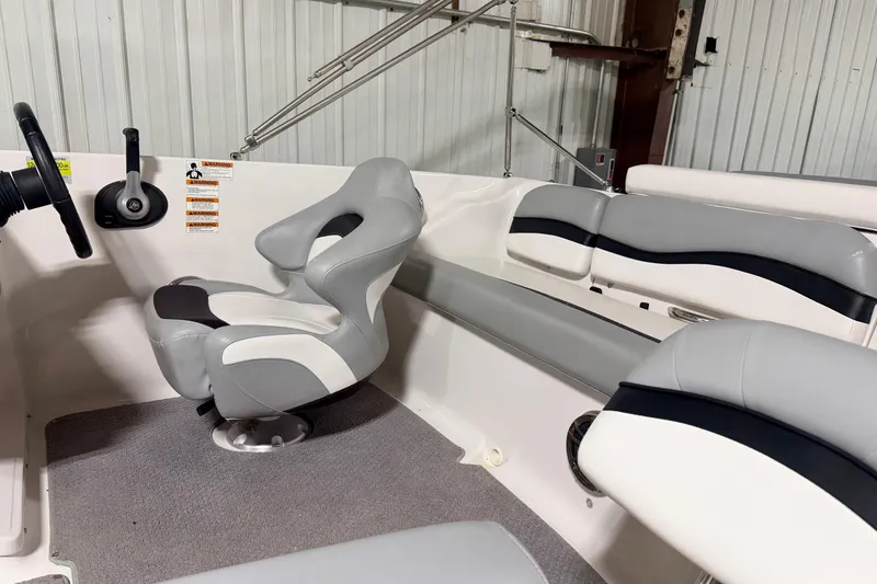 Slide: The Image of Interior of a 2014 Starcraft 2000 IO Limited boat with gray and white seating. - 13