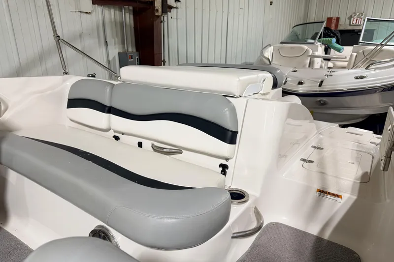 Slide: The Image of 2014 Starcraft 2000 IO Limited boat interior with gray and white seating in a storage facility. - 14