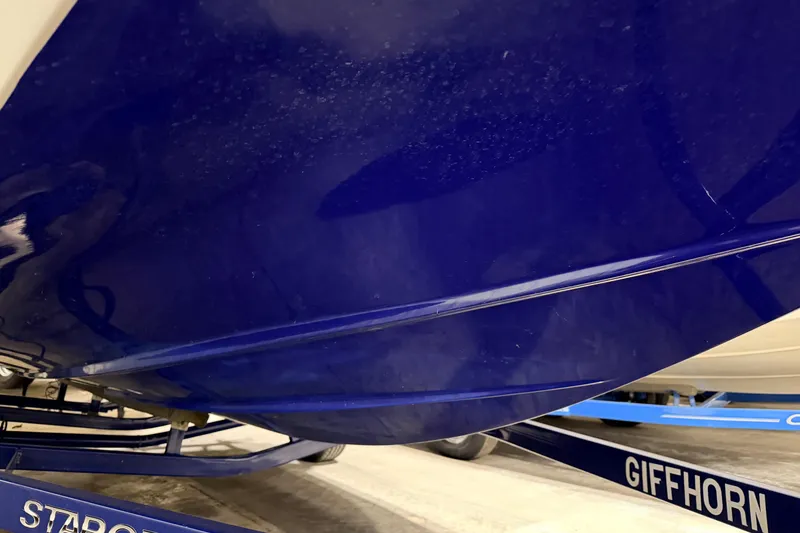 Slide: The Image of Blue hull of a 2014 Starcraft 2000 IO Limited boat on a trailer. - 18