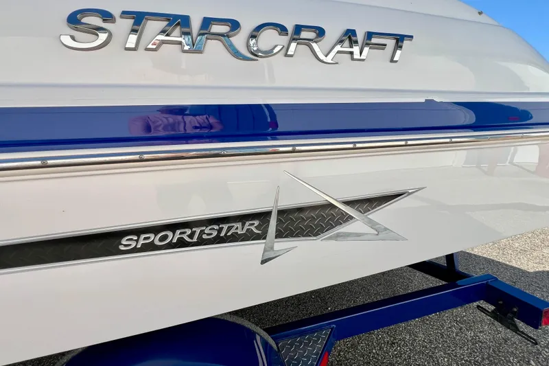 Slide: The Image of 2014 Starcraft 2000 IO Limited boat with Sportstar branding and blue accents. - 5