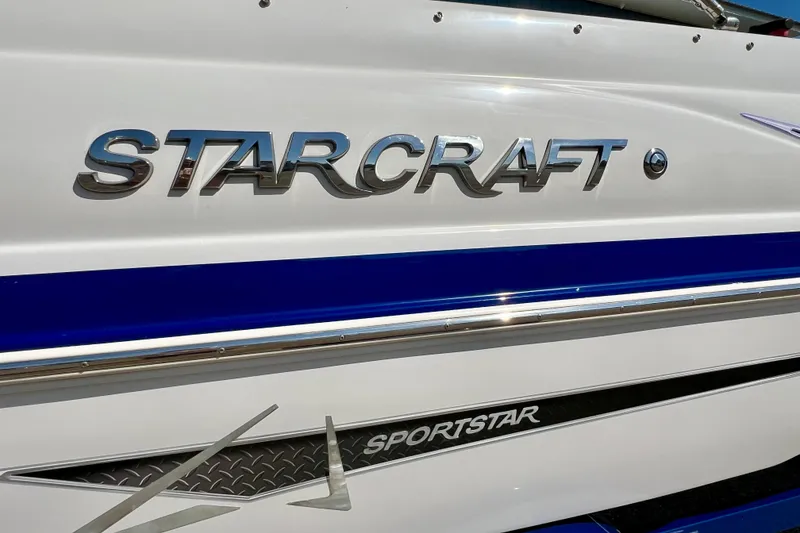 Slide: The Image of 2014 Starcraft 2000 IO Limited boat with Sportstar branding, featuring sleek blue and white design. - 7