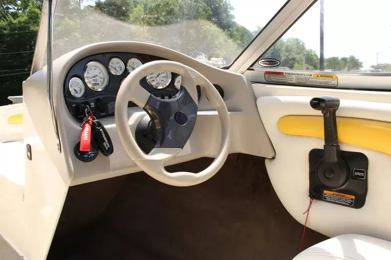 Slide: The Image of Interior view of a 2004 Stingray 180 LX boat with steering wheel and dashboard. - 11