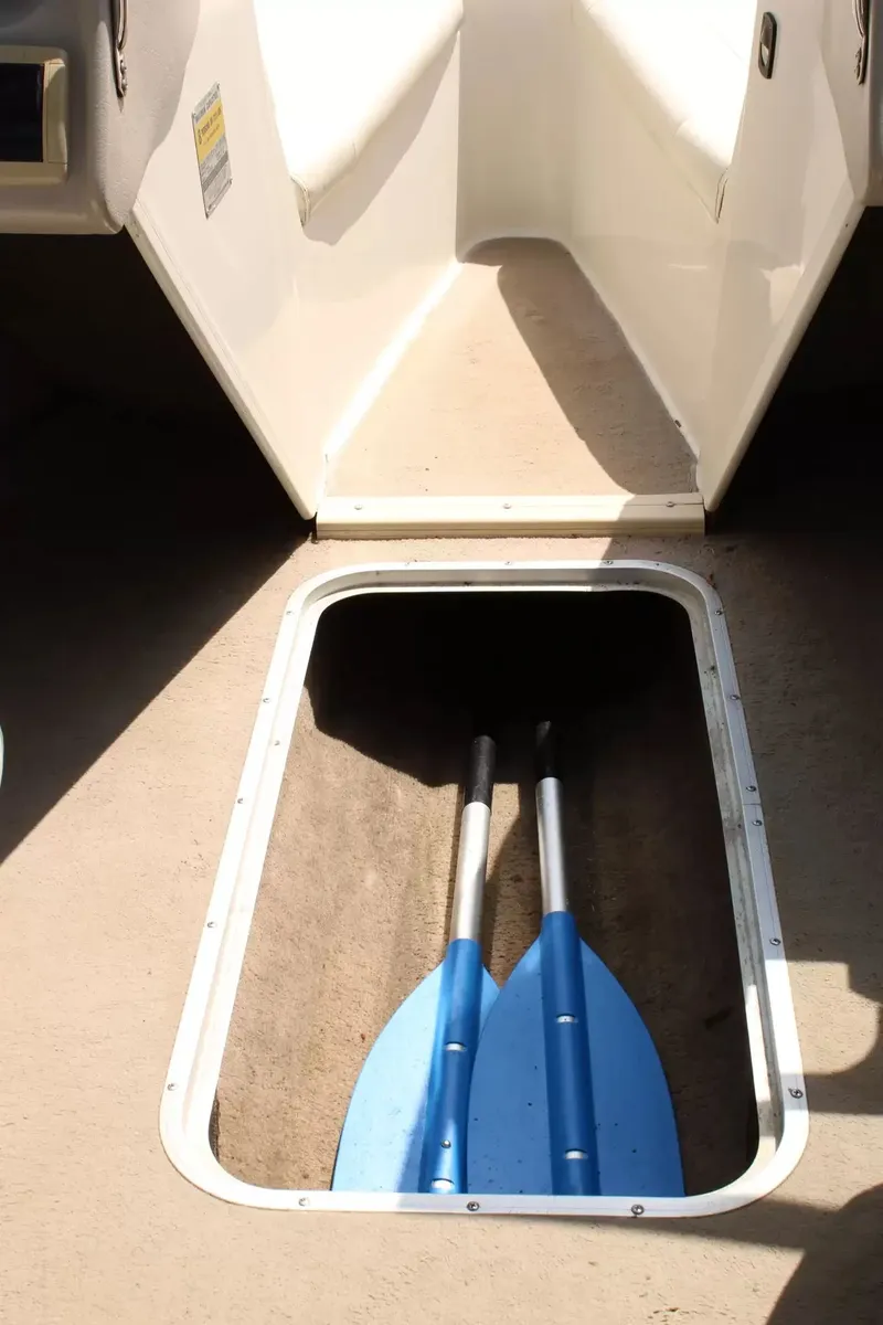Slide: The Image of 2004 Stingray 180 LX boat with blue paddles in storage compartment. - 16