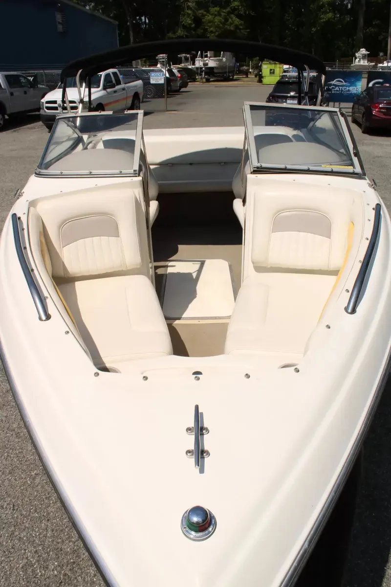 Slide: The Image of 2004 Stingray 180 LX boat with open cabin, parked on asphalt. - 23
