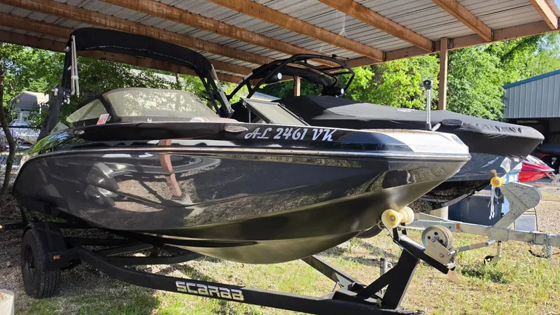 Slide: The Image of 2019 Scarab 195 ID boat parked under a carport. - 2