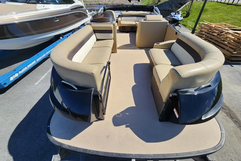 Slide: The Image of 2017 Larson Escape RT 2400 Cruise Triple pontoon boat with beige seating and spacious deck. - 11